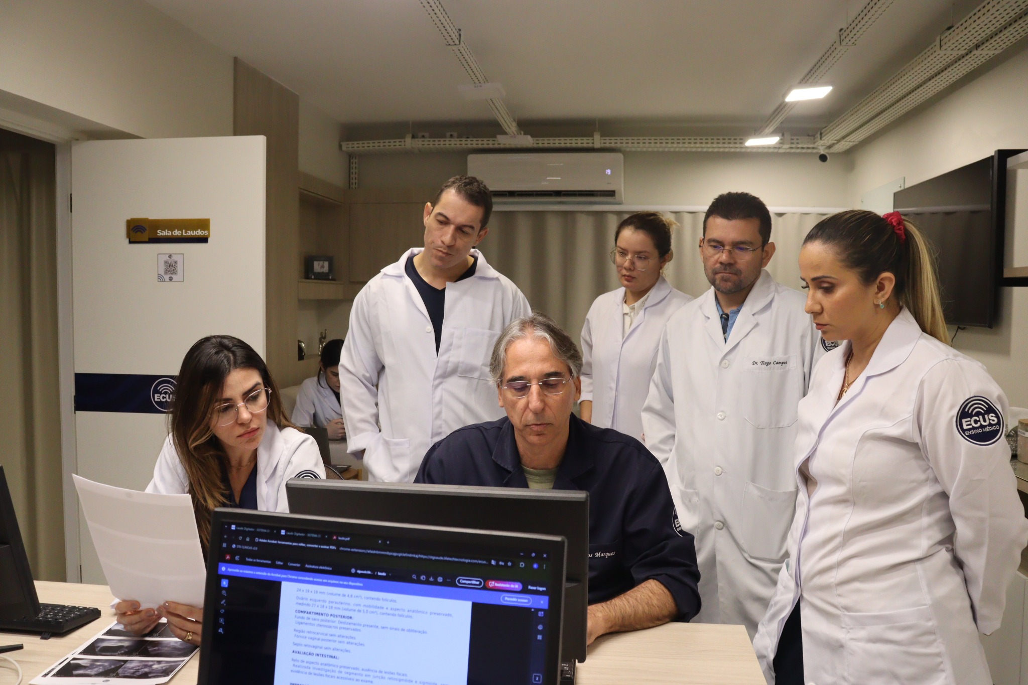 Discussão de laudos em mesa com equipe médica